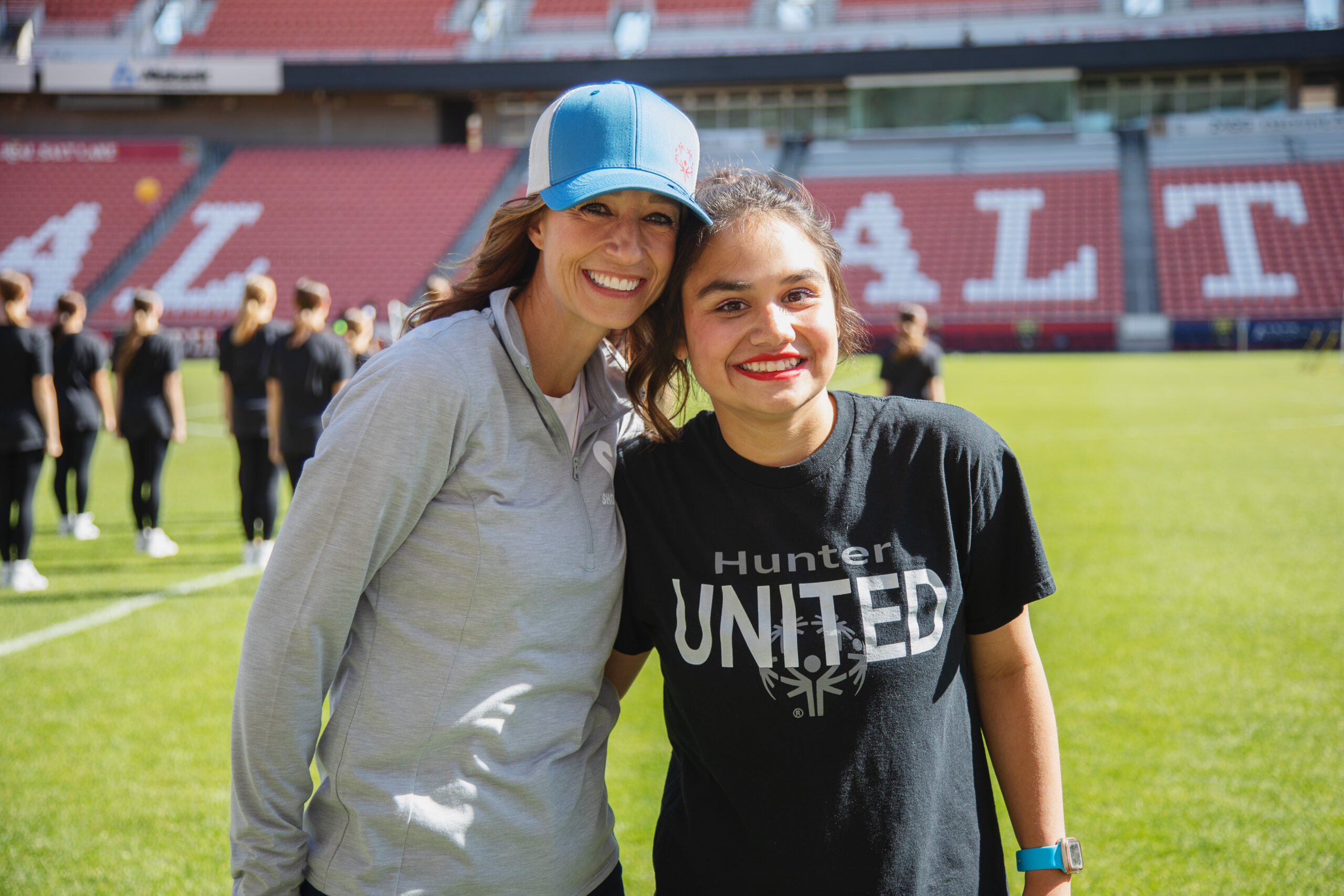 Two smiling women on a football field